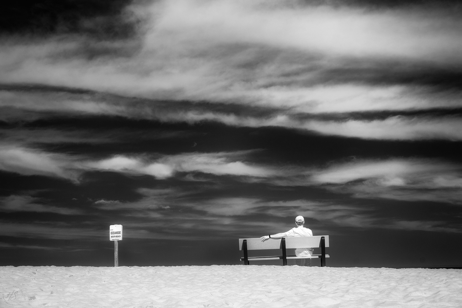 2021_05_Assateague-11026-Edit2048.jpg - Waiting and Watching.  Okay, maybe not.  Maybe I just asked Mike to go sit on that bench because I liked the clouds and had my IR camera in my hand and wanted to get a cool shot on the beach.