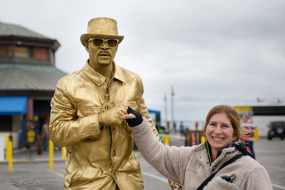 _JMS0057.jpg - Hali exchanges greetings with a statue.  Or a statue-like person with cool sound effects.  Pier 39.