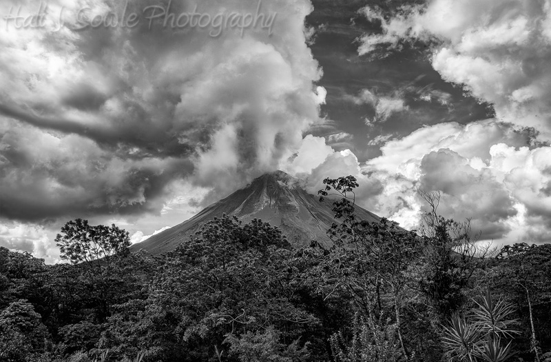 CostaRica_37.JPG - Arenal Volcano from behind our room at the Arenal Volcano Observatory Lodge. The Arenal Volcano  is the youngest of the mountains in Costa Rica and until 2010 it was the most active.  Since 2010 there have been no explosive eruptions but we could see smoke trailing from the vents every day when the clouds were not closed in.  It might not be actively erupting but it is not dormant.