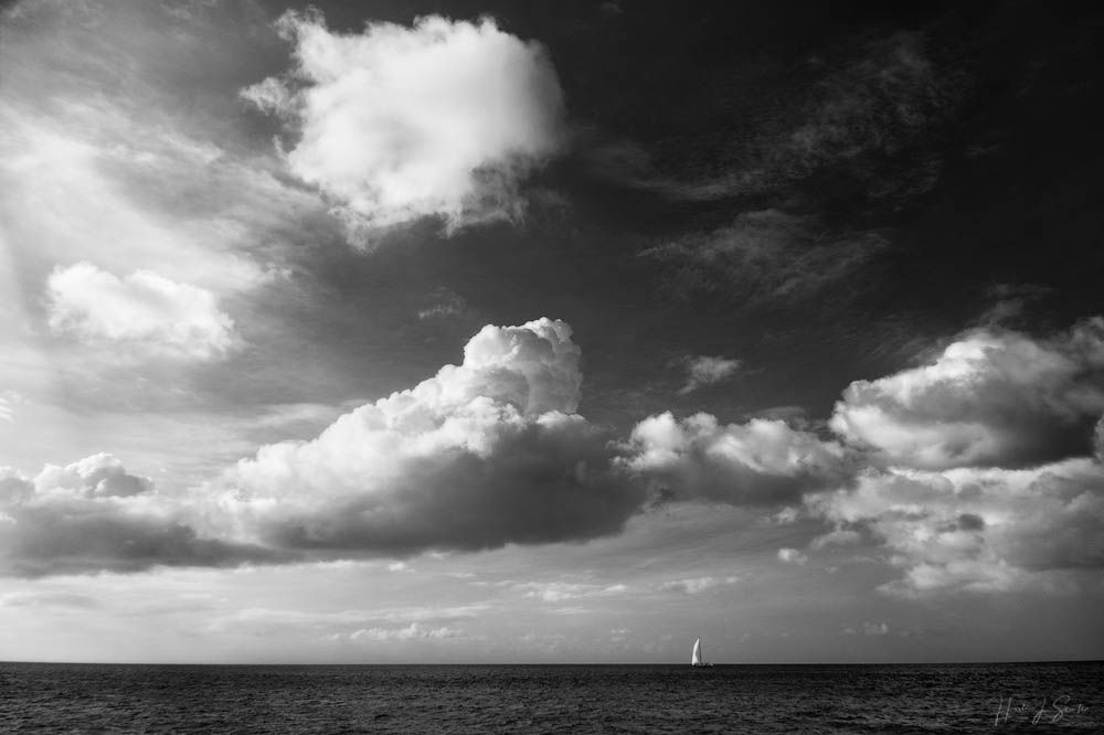 2018_11_SandalsGrenada-10273-Edit1000.jpg - The grand landscape of the Caribbean Sea and a beautiful sky with a sailboat flying it's jib.  Infrared.