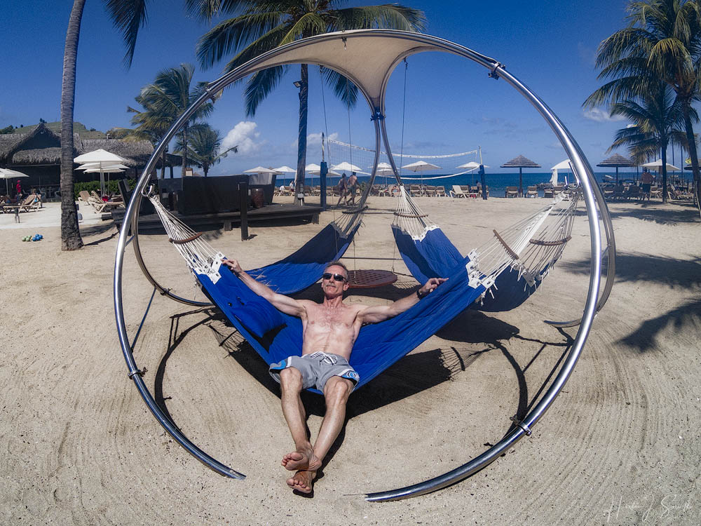 GOPR1381-Edit1000.jpg - The beach at the resort was very well kept and had plenty of umbrellas and chairs and  they also had a bocce area, some individual hammocks and this cool circular hammock area.  Mike was kind enough to pose for me on another brilliant day.