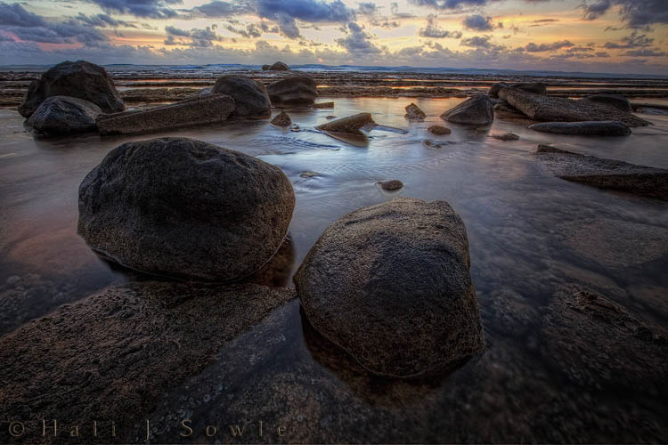 2009_10_01_Hawaii-10001_2.jpg - I loved these big boulders in the shallow protected breakwater area in front of the hotel.  There was only about 4 inches of water and in stark contrast to the heavy surf outside the water here was just a gentle lapping with the occasional small wave as a wave made it around the breakwater.  I'm sure it wasn't good for my tripod no matter how well I rinsed it after, but it was hard to resist getting my feet wet for dawn.  Mike was still sleeping!