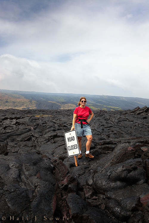 2009_10_02_Hawaii-10283.jpg - Hali standing on the cooled lava that overflowed the Chain of Craters Road in Volcano National Park.  This lava is from the 2004-2007 eruption and showed very little breakdown and absolutely no plant growth for as far as we could see (except for one small grove of coconut palms that the lava completely went around)