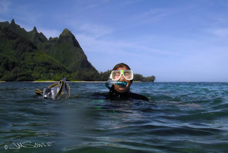 P9300041Adj.jpg - Hali coming up for a breather during our Tunnels snorkeling trip.  The beautiful Na Pali coastline is the back drop.  What a great day!