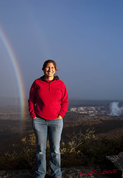 _DSC0063.jpg - It's late afternoon, and a little rain had just blown through.  A double rainbow formed in front of our eyes.  This is a shot of Hali in front of the Kilauea crater -- taken from the visitor's center of the Hawaii Volcanoes National Park.  The inner crater is visible in the background.