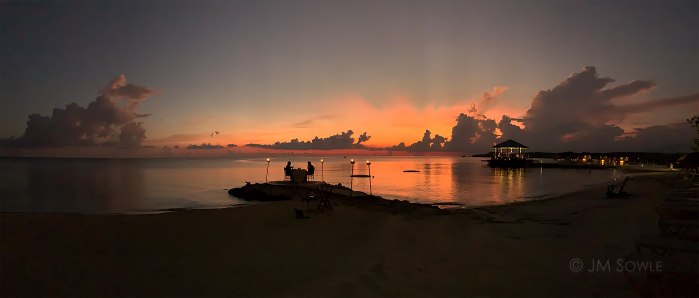 IMG_E9086_1400.jpg - A phone panoramic image of some wonderful post-sunset light.  There is a couple having dinner on one of the breakwaters and the over the water bar is getting ready for a busy night.
