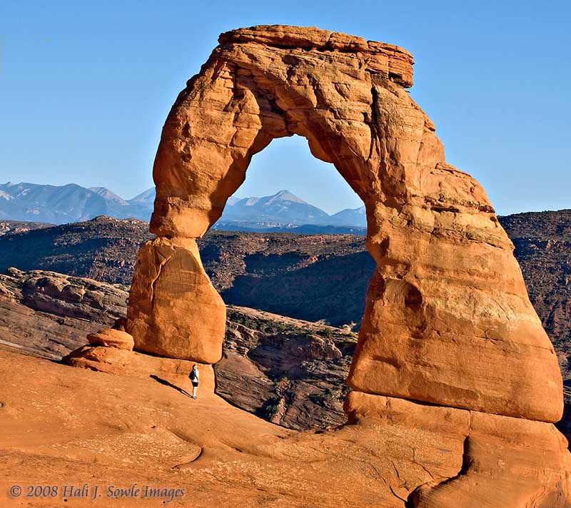 2008_09_02_Moab_324.jpg - Unknown hiker looking up at Delicate Arch as the sun begins to set