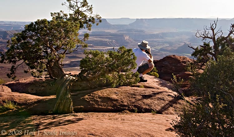 2008_09_03_Moab_250.jpg - Mike standing perilously close to the edge at White Rim overlook taking a picture of the Green river.