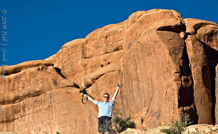 2008_09_04_Moab_310.jpg - Mike celebrating victory over the rock.  We were looking for an alternate view of Double Arch in the late afternoon, we drove up to the parking lot then back along the road trying to find the view Mike saw briefly.  Mike scrambled up this rock to try and see it but no luck.  It was there, problem was we just never drove back far enough to see it.
