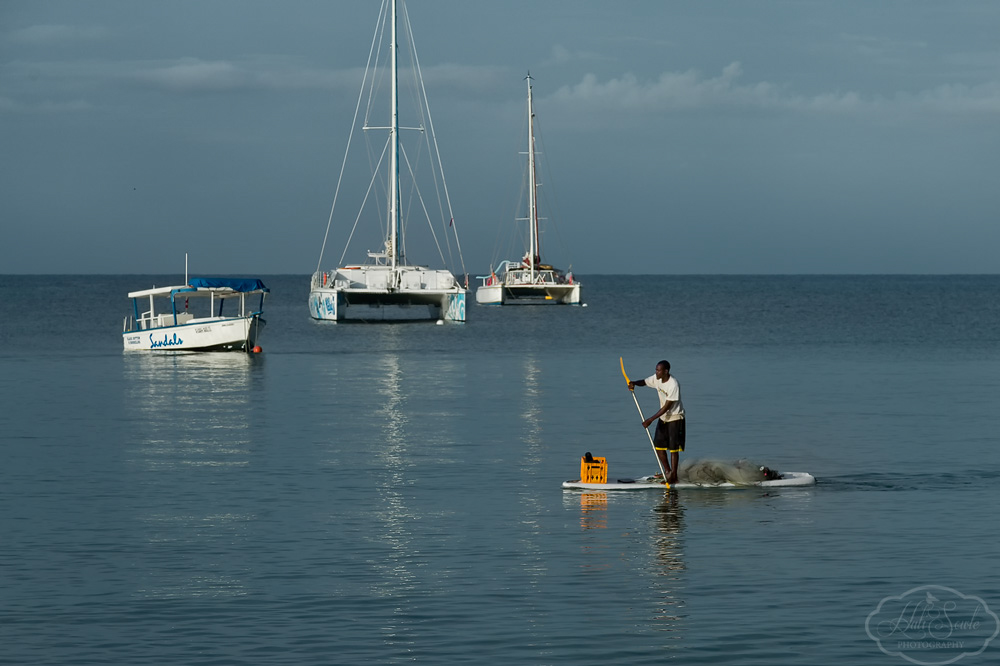 2014_01_SandalsNegril-10730-Edit1000.jpg - Off to work.  One of the locals paddling his way across the bay early in the morning.