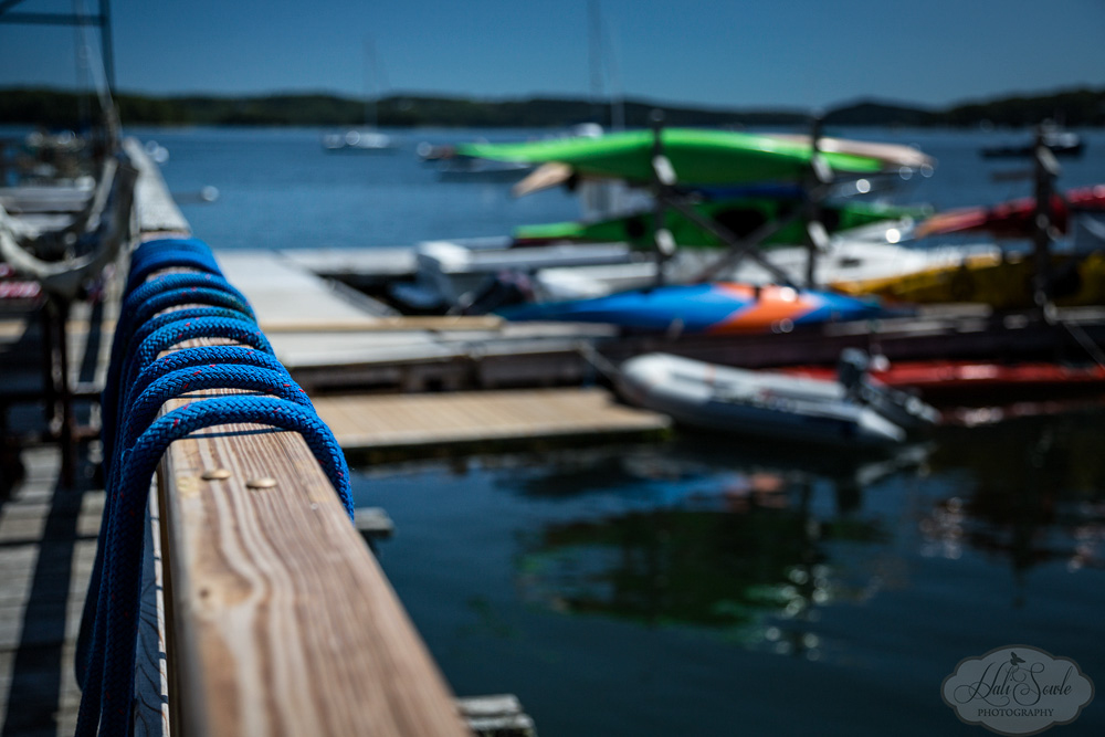 NovaScotia_06.JPG - We visited a marine repair shop where we also encountered a bigwig from the Rhode Island/Massachusetts area automobile dealerships docking his yacht.  This late in the season most of the kayaks and other recreational craft that were available for rent were still in their cradles instead of out on the harbor.  I thought this point of view of the lines and the dock was interesting