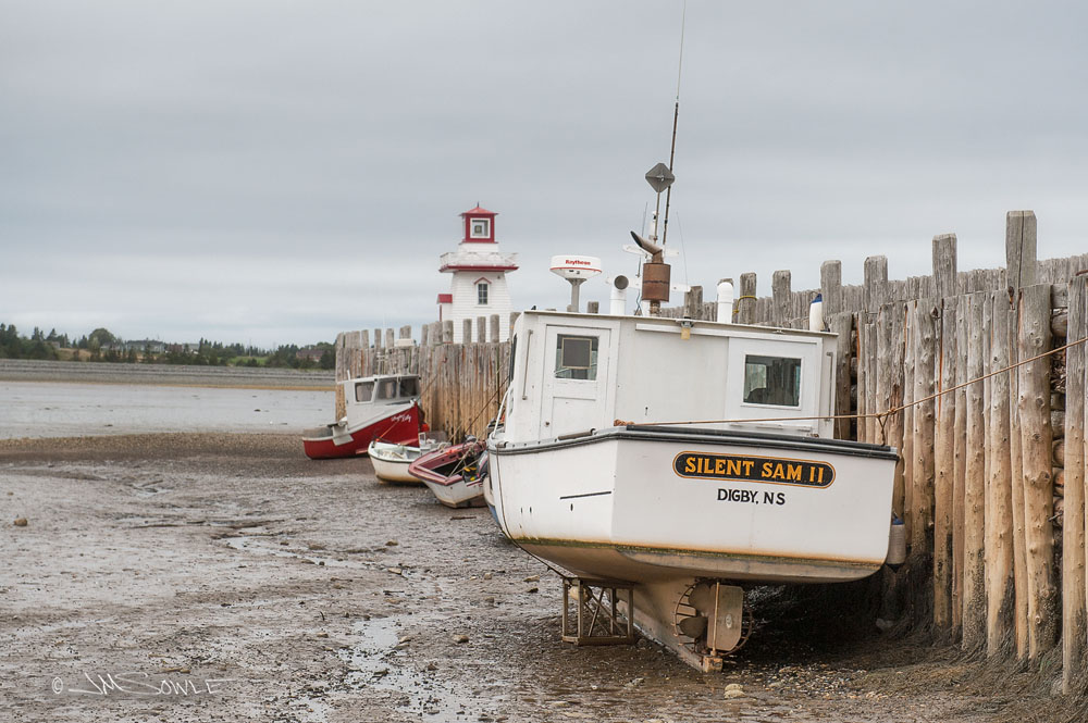NovaScotia_43.JPG - The bad news is that you have to be really careful when you tie your boat to the dock in this region.  The good news is that it's really easy to access your hull -- just wait for the tide to go out!  That is Belliveau Cove Lighthouse in the near background.  Belliveau's Cove, Nova Scotia.