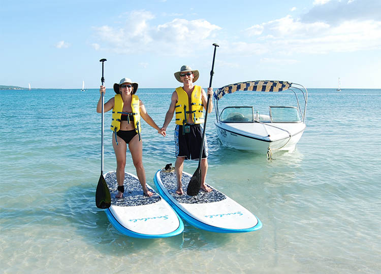 008_8ADJ.jpg - The sailing equipment was not great, but they had some new-looking stand-up paddle boards that were a lot of fun.  This shot is from a resort photog, taken when returning from a paddle.  The ski boat is next to us.